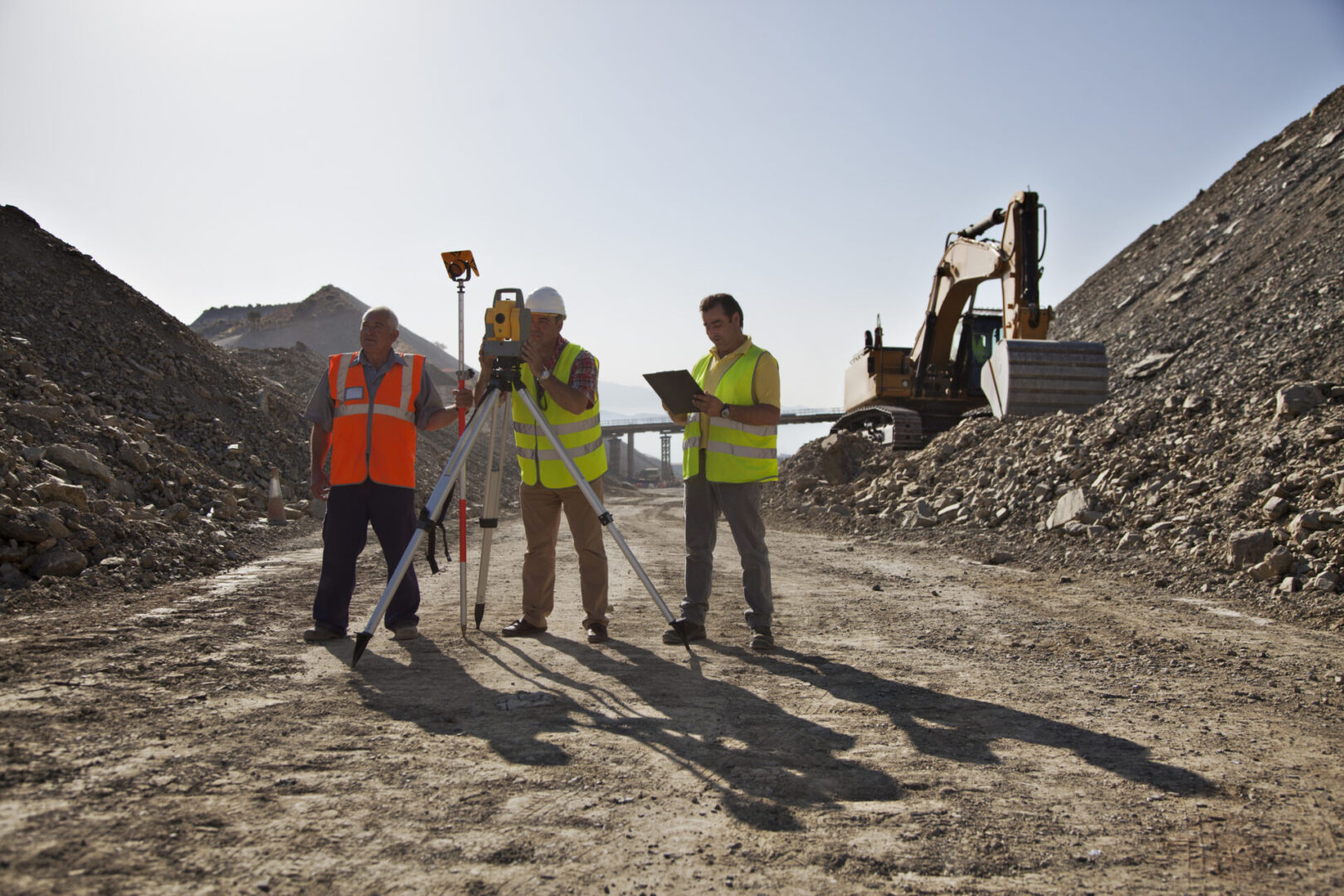Workers using leveling machinery in quarry